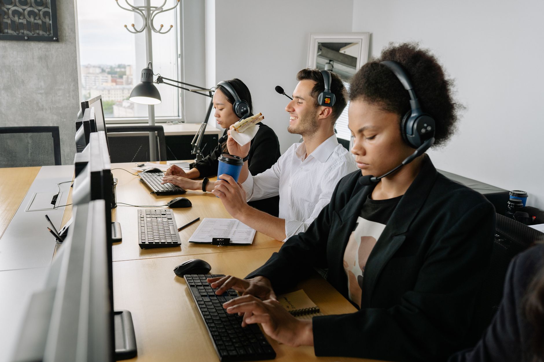 A diverse group of call center agents working together in a modern office setting.