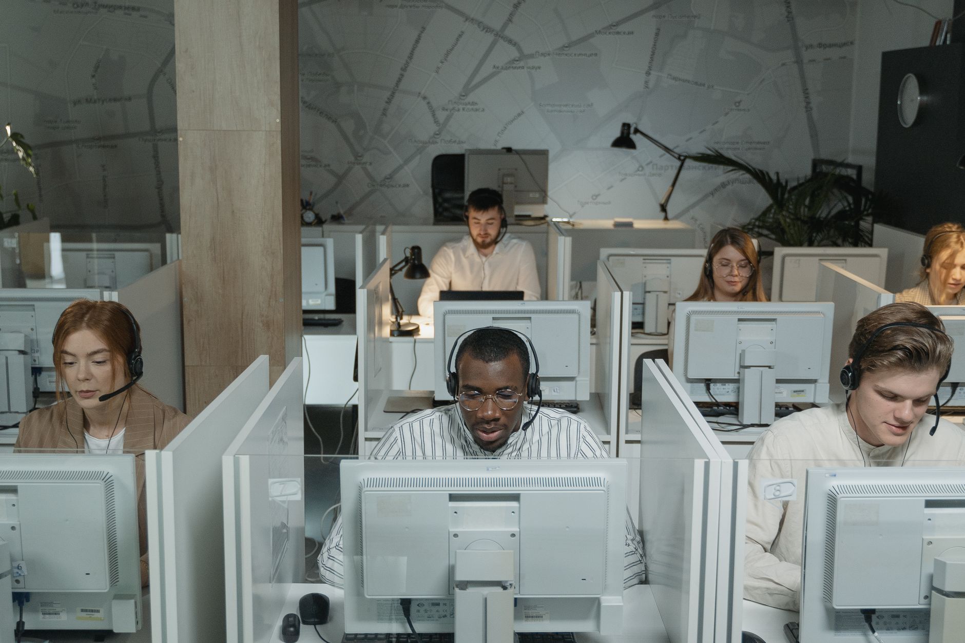 A diverse group of call center agents working in an organized office setting, focused on assisting customers.
