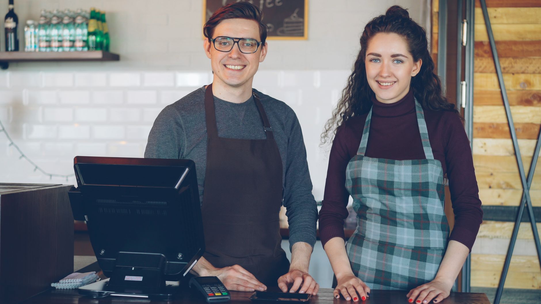 Cafe staff smiling at the counter, ready to assist customers.