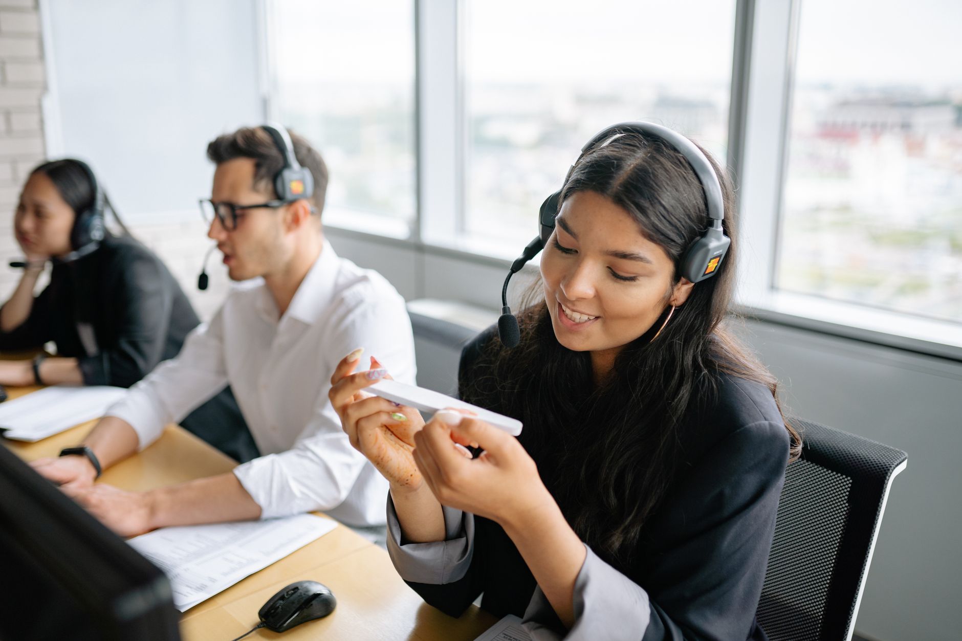 Diverse call center agents working collaboratively in a bright office environment.