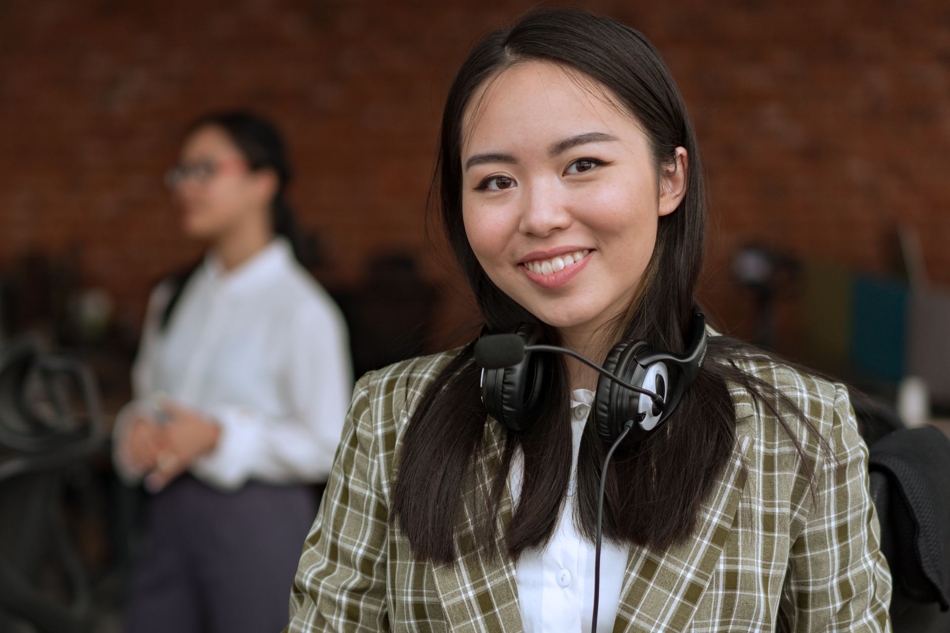 Smiling professional woman wearing a headset in an office environment, exuding confidence.