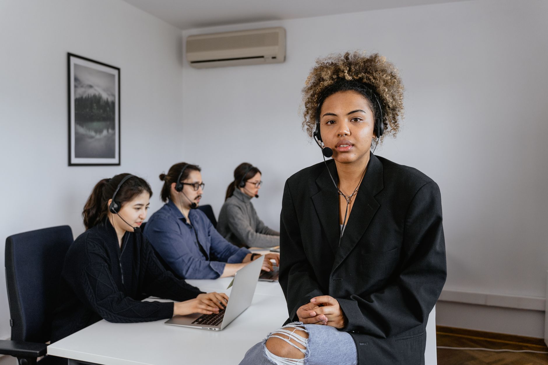 Diverse customer support team working in a modern office setting.