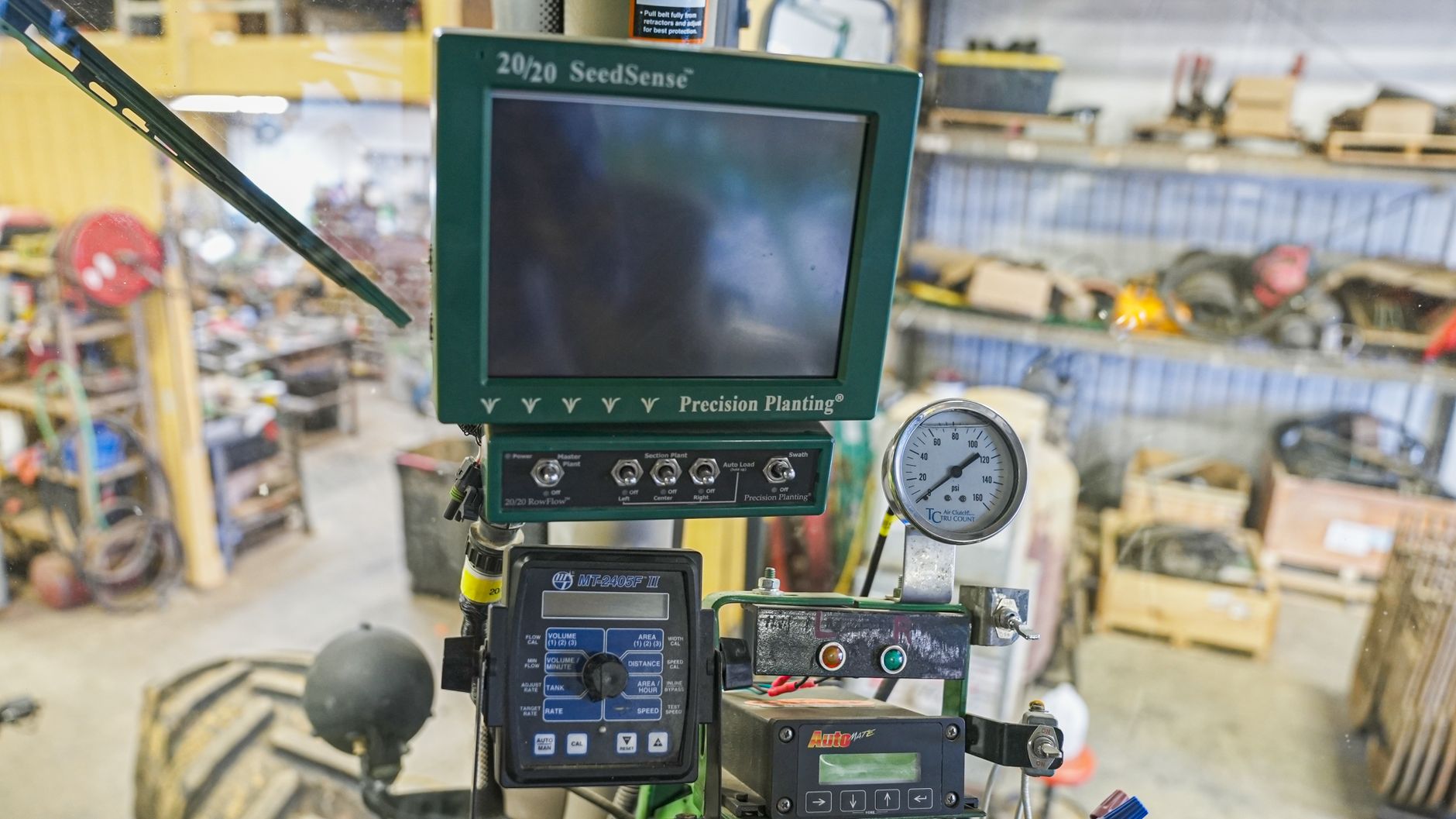 Close-up of SeedSense precision planting device in agricultural workshop, showcasing modern farming technology.