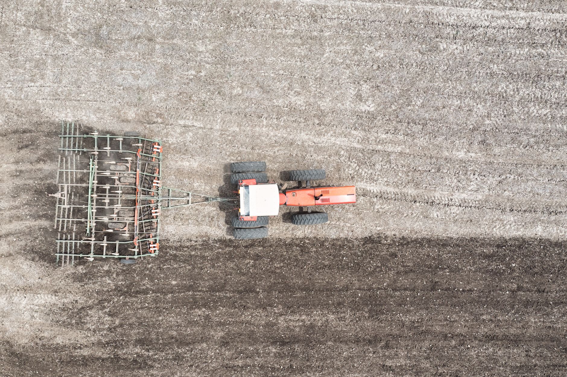 Aerial photograph of a tractor plowing a rural field in Minnesota, showcasing agricultural practices.