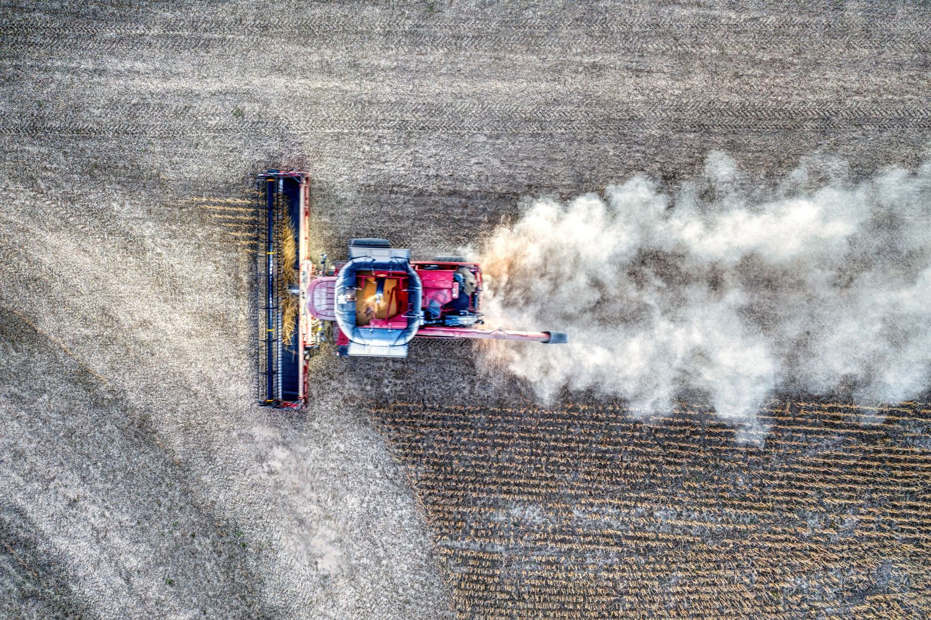 Drone shot capturing a tractor harvesting crops on farmland in Minnesota.