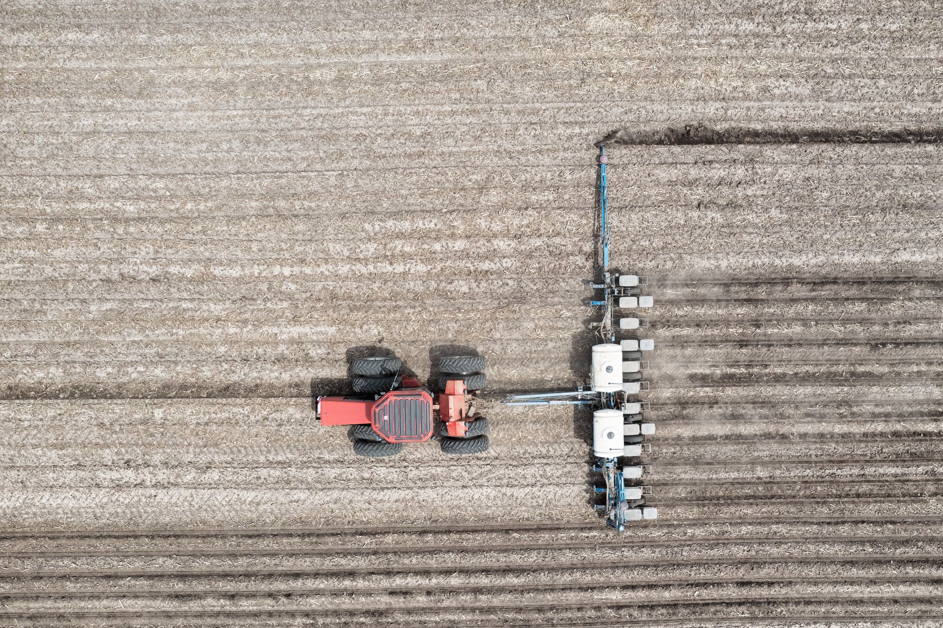 Aerial shot of a tractor plowing farmland in Minnesota, showcasing efficient agricultural machinery.