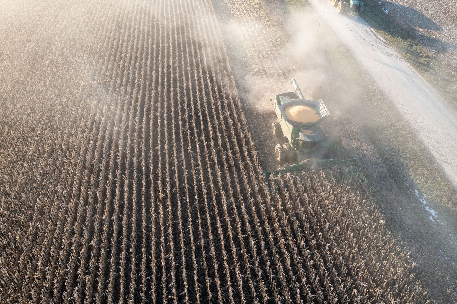 Aerial shot of a combine harvester in a cornfield near Theilman, MN, during the day.