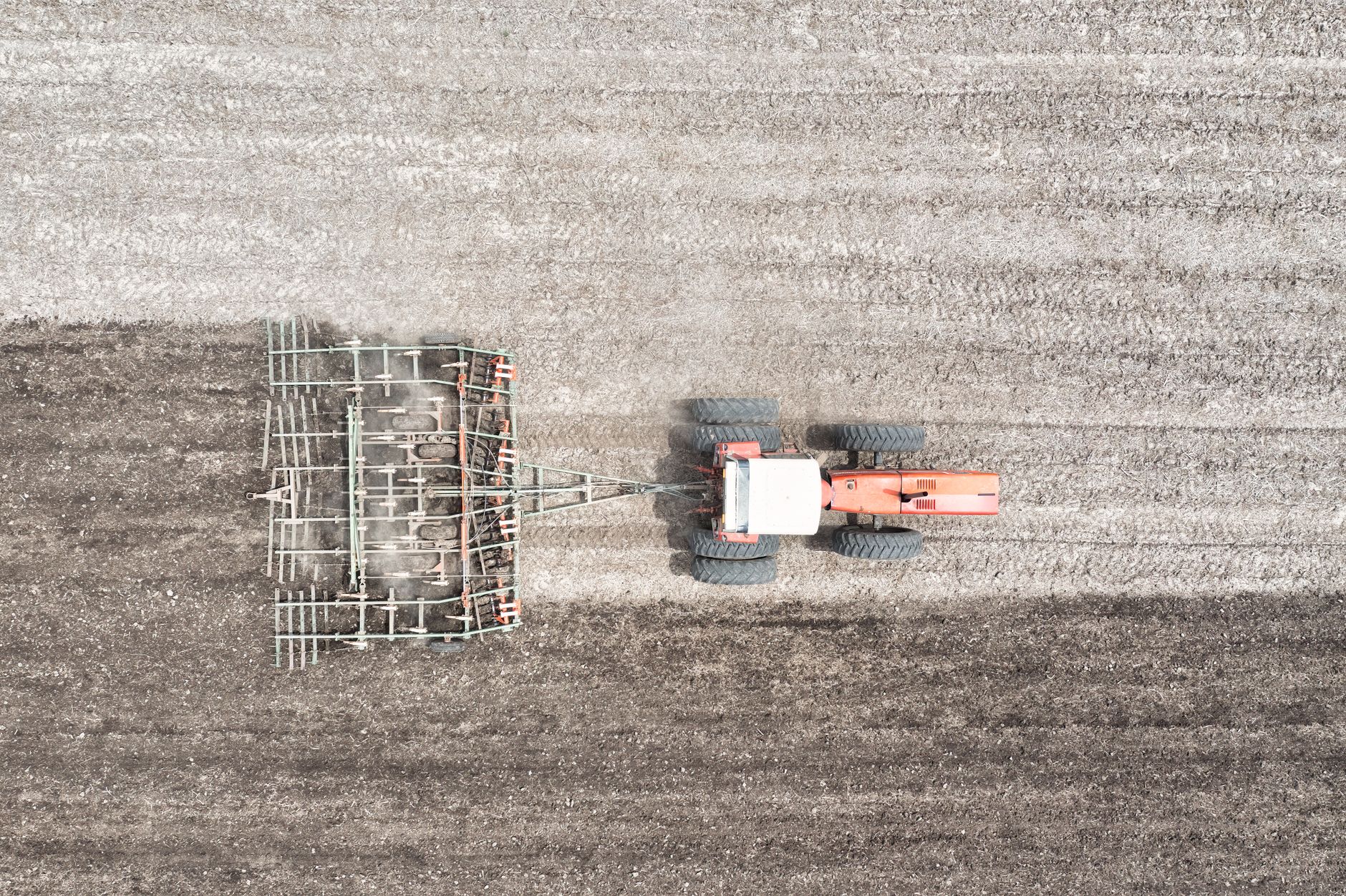 Top view of a tractor plowing agricultural land in Minnesota, showcasing farming machinery in action.