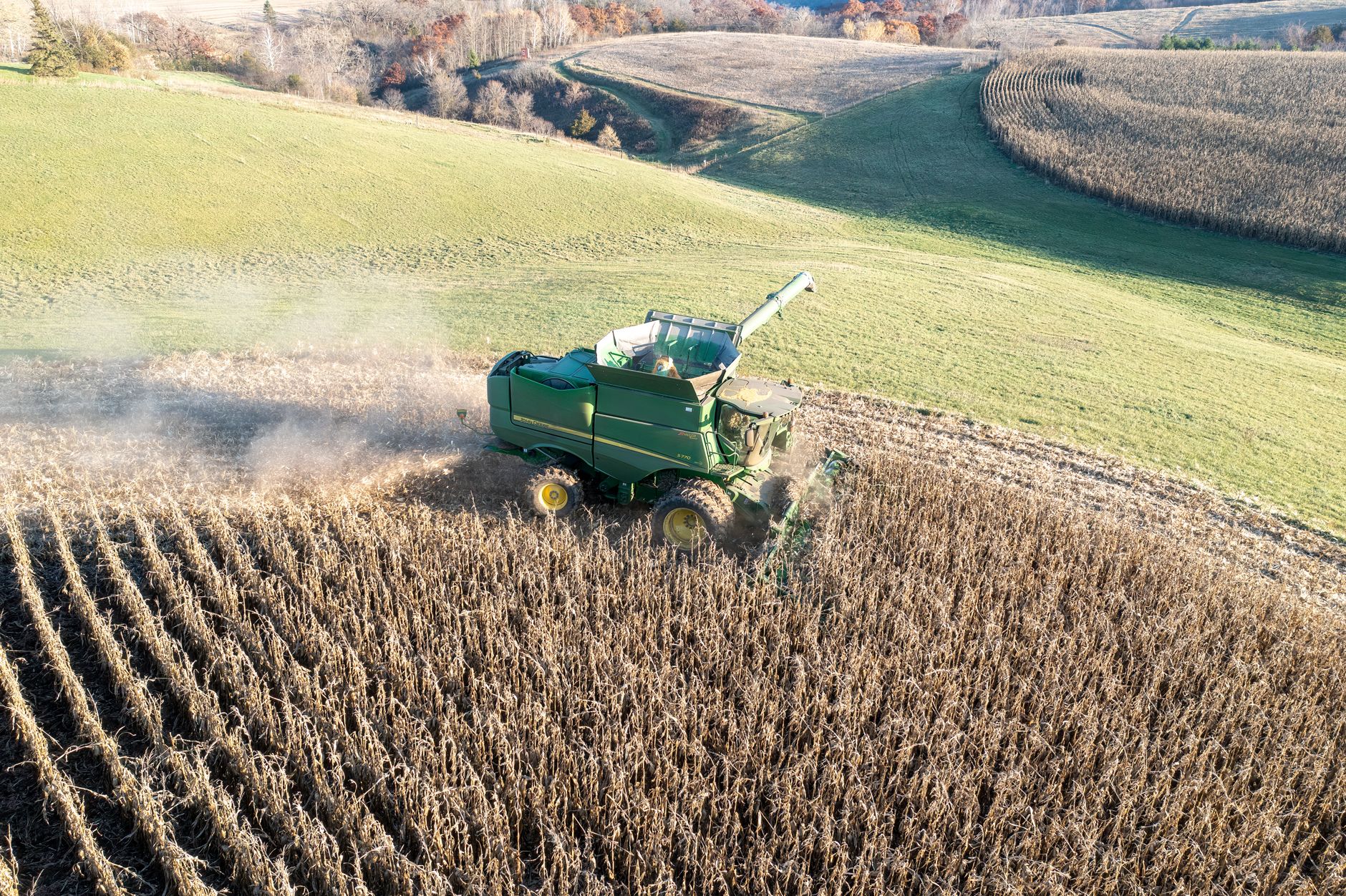 Aerial view of a combine harvester working on corn fields during fall in Theilman, MN.