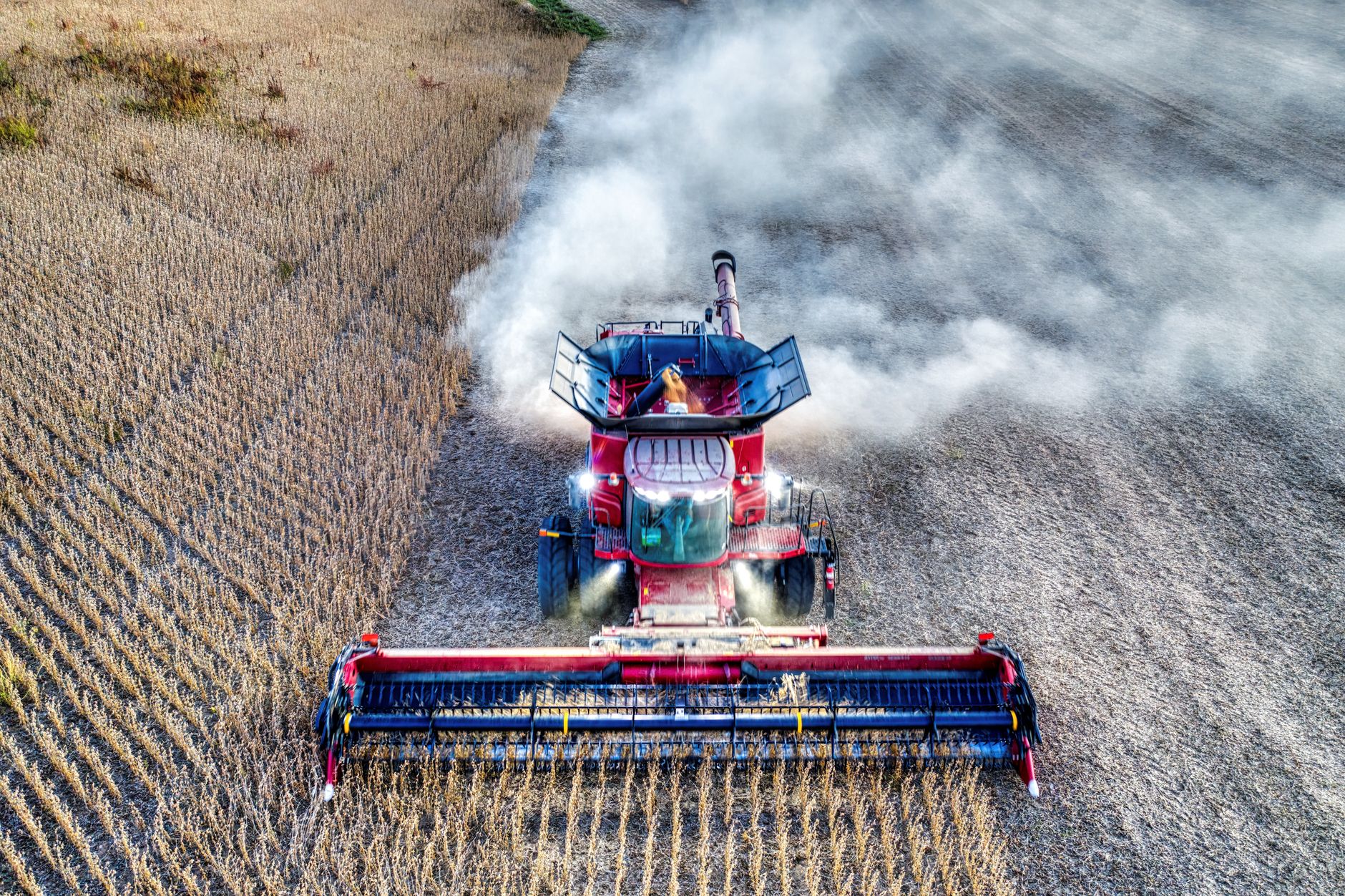 Aerial shot of a red harvester working in a Minnesota field during harvest season.