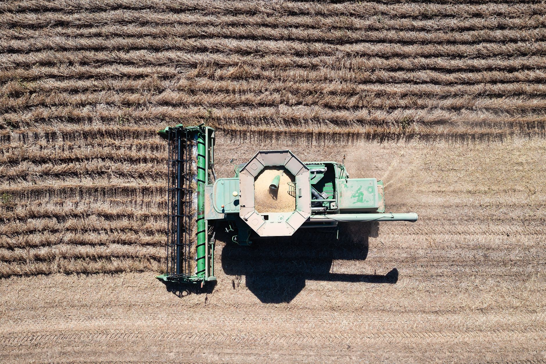 Drone shot of a combine harvesting a field, showcasing agricultural machinery in action.