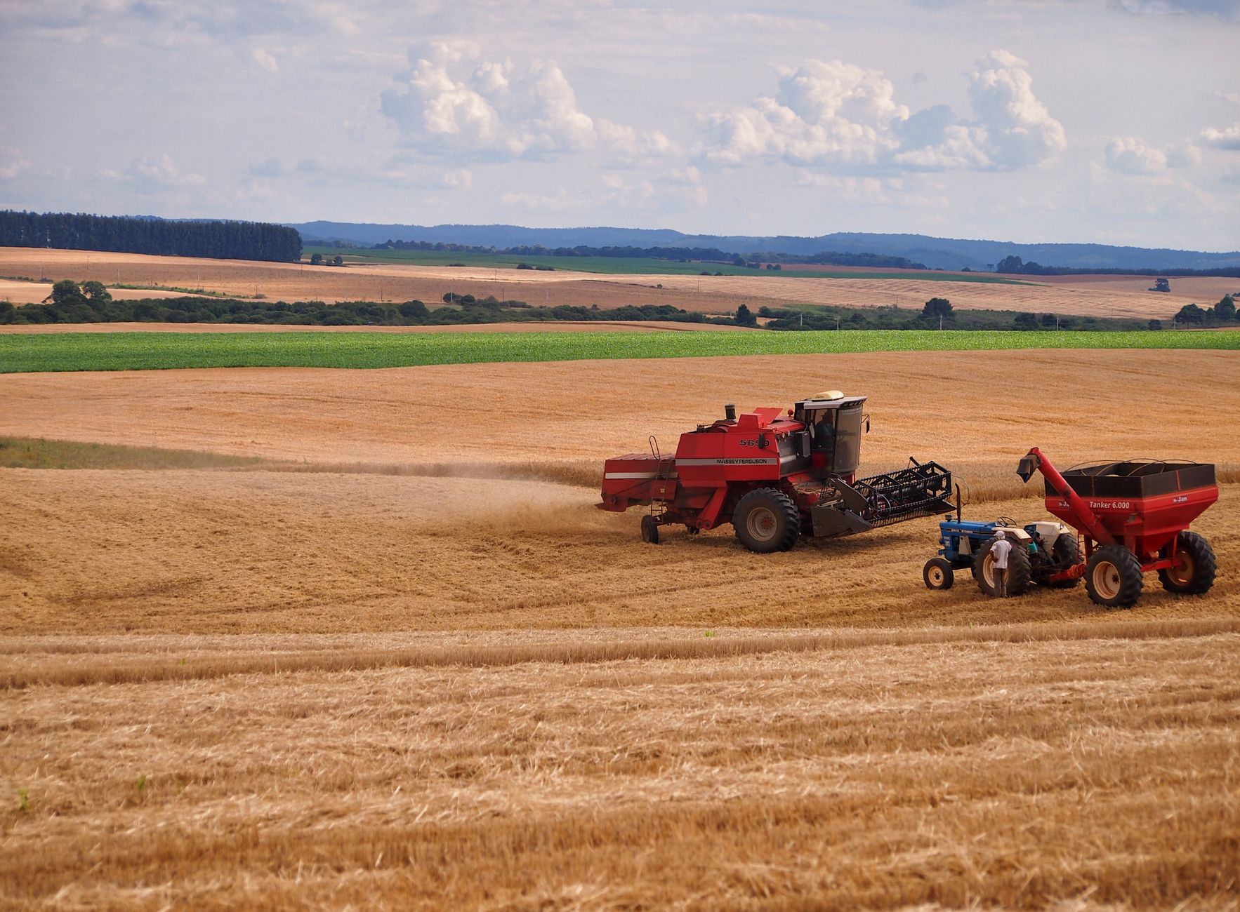 Field scene with a harvester and tractor during harvest in Entre Rios, Brazil.