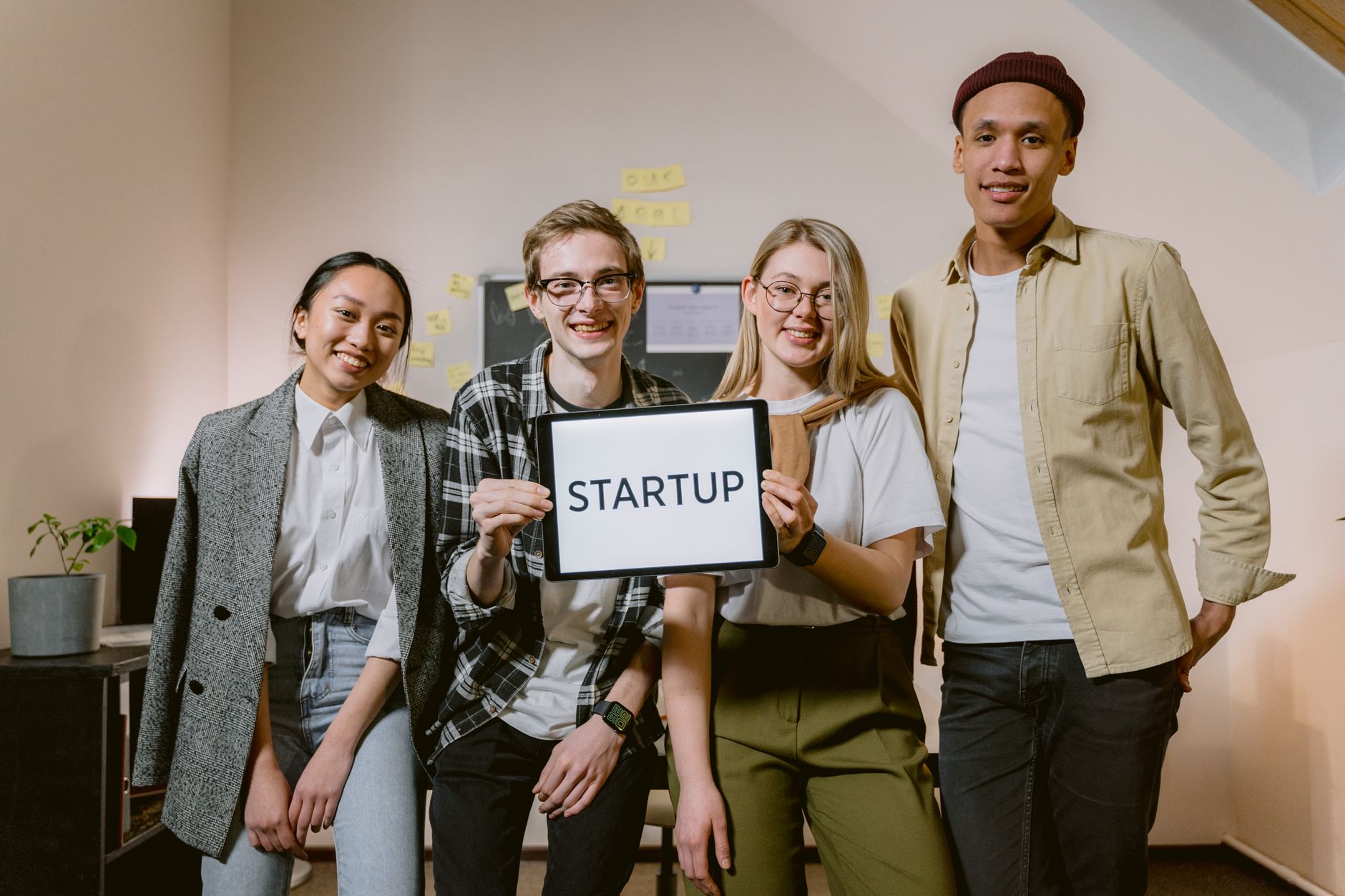 A diverse group of smiling young professionals showcasing teamwork in a startup environment.