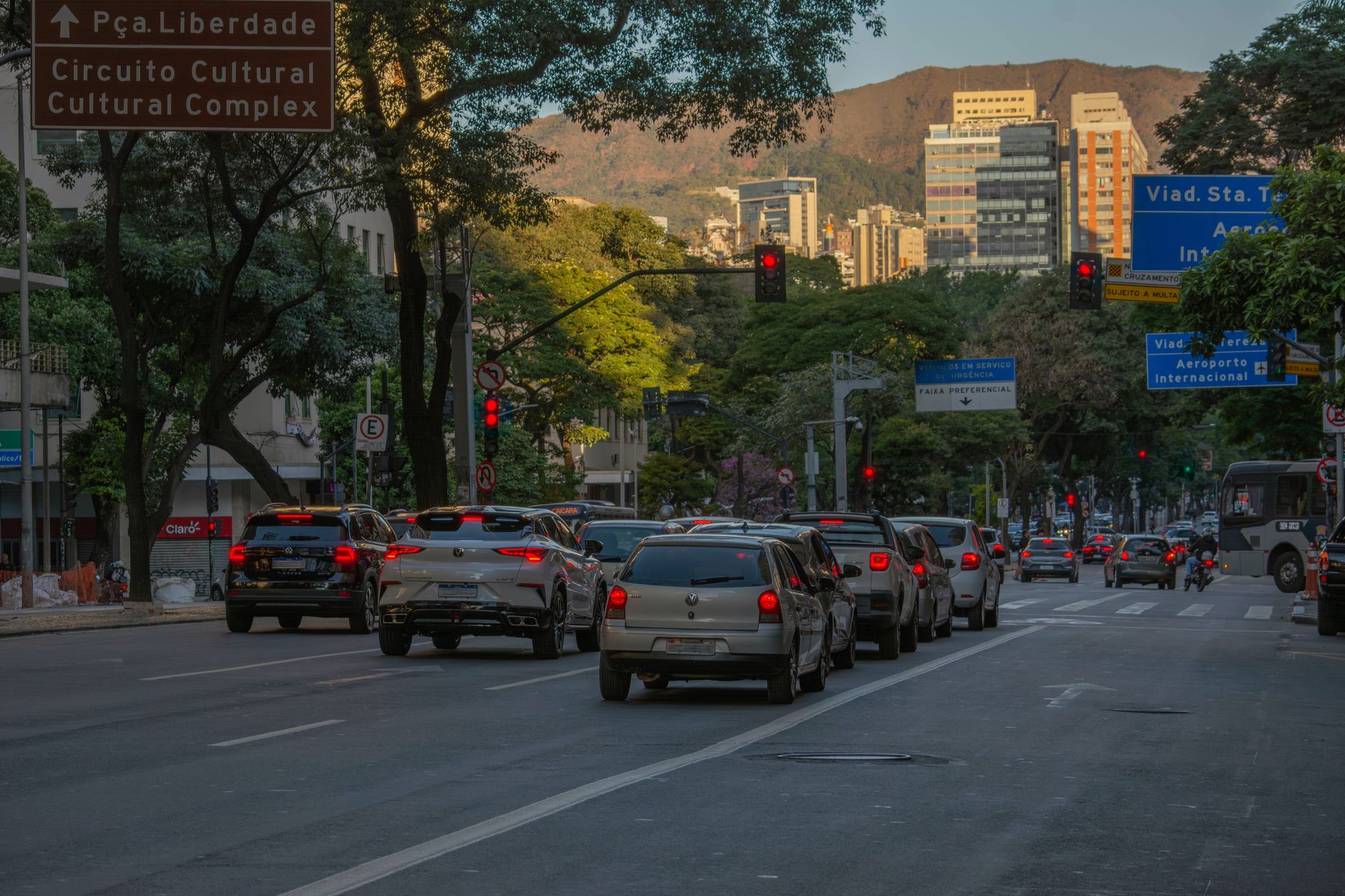 A bustling city street scene with cars and buildings at sunset in Belo Horizonte, Brazil.
