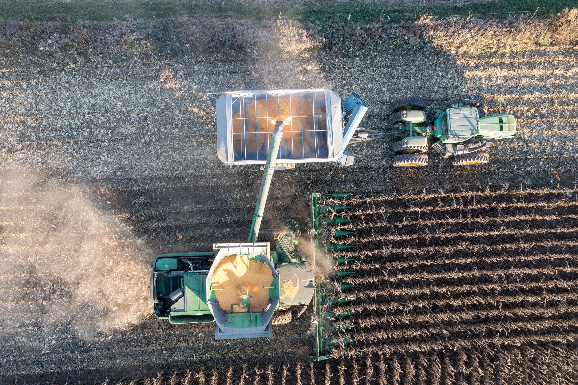 Drone shot of tractors harvesting crops in rural Theilman, Minnesota.