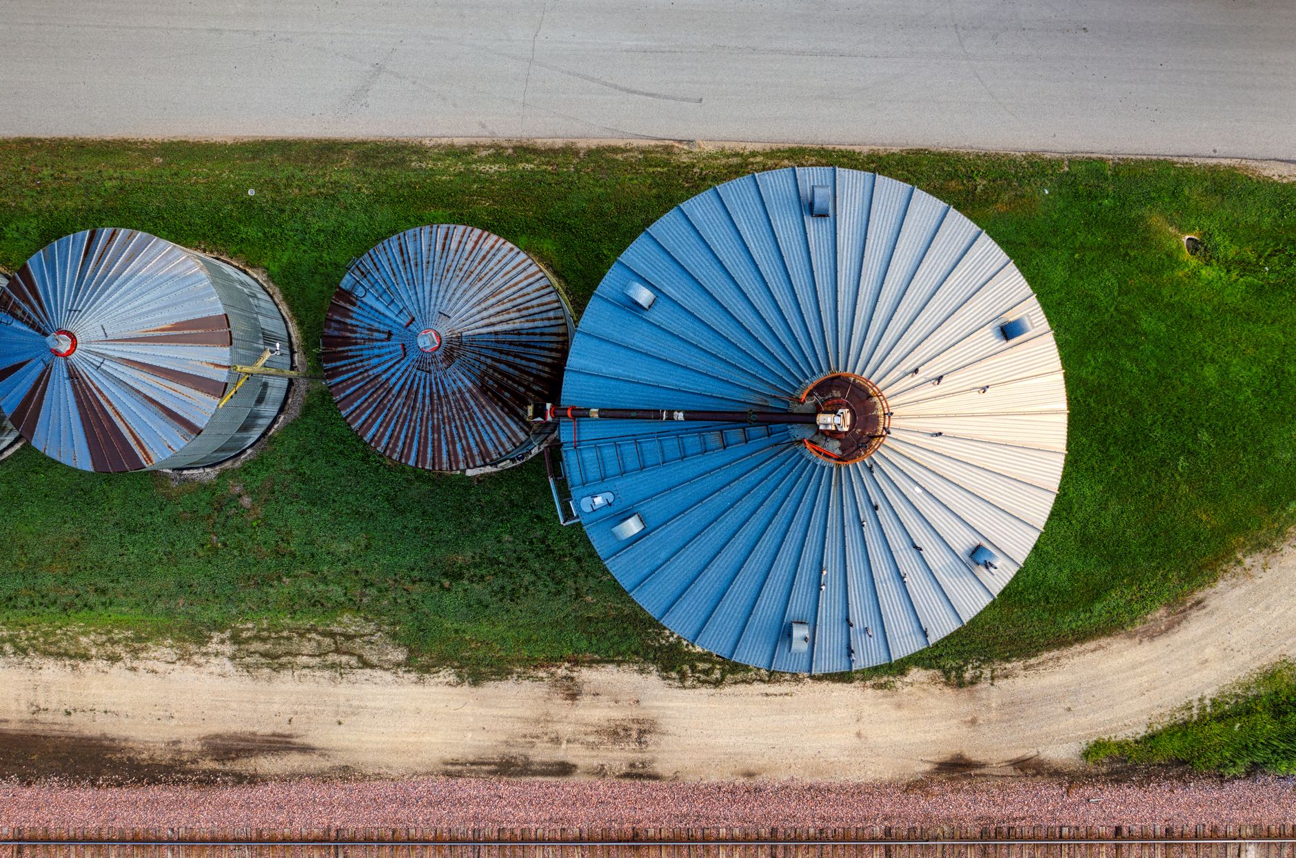 Drone shot capturing top view of three large silos on a Minnesota farm.