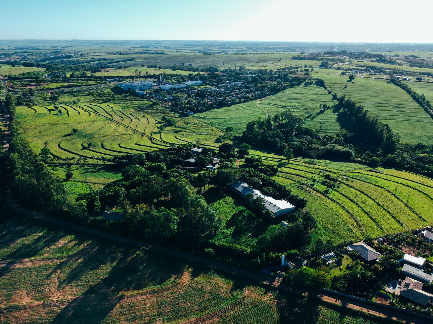 A stunning aerial view of the lush countryside in Maringá, Brazil, showcasing farmland and rural landscapes.