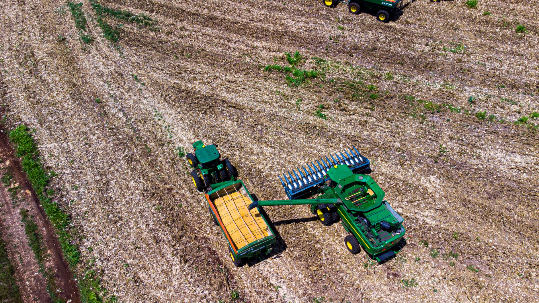 Drone captures tractors harvesting corn in San Isidro Chuncopó, Yucatán, showcasing rural agriculture.
