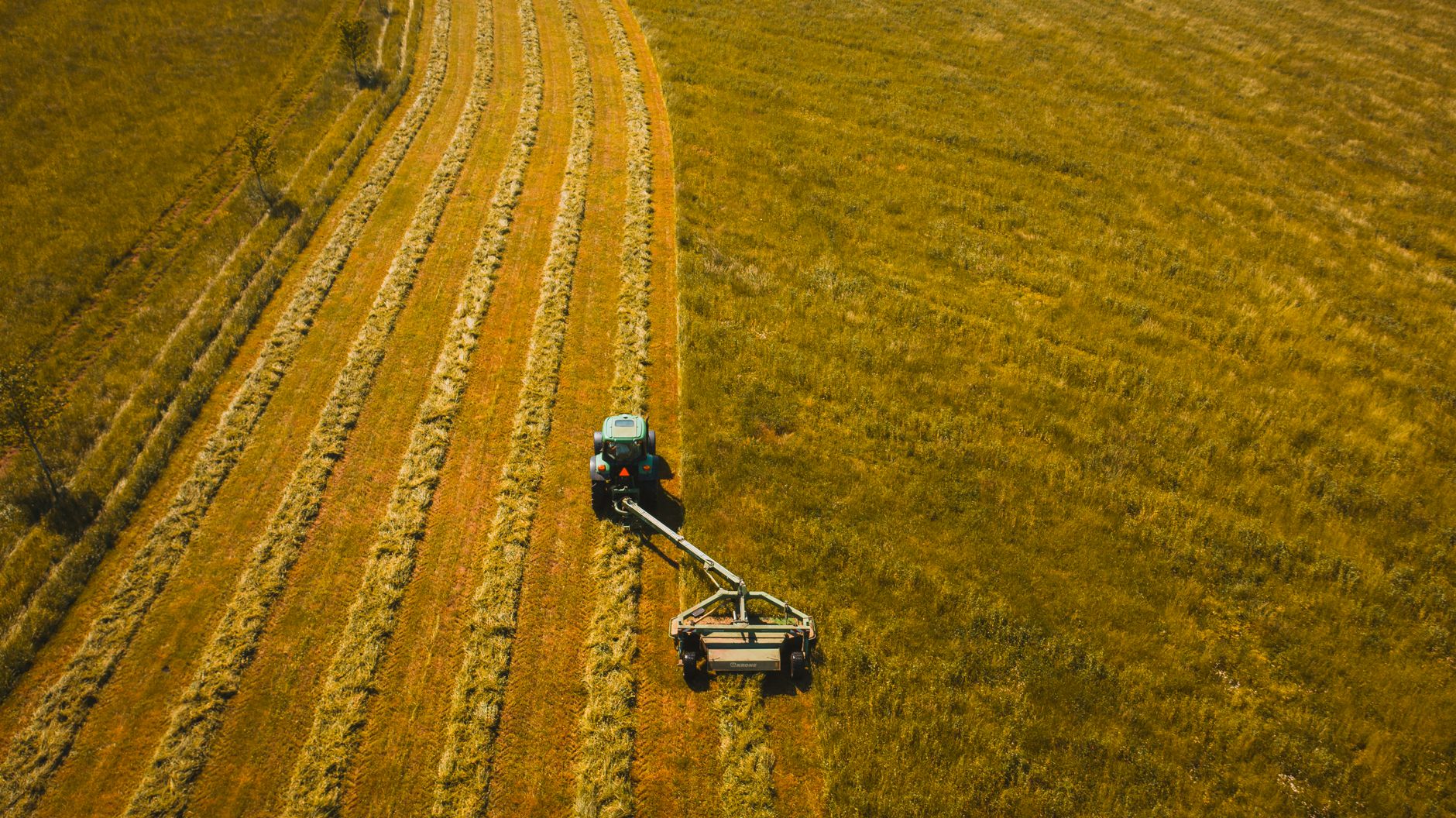 Aerial shot of a tractor cultivating farmland in rural Tennessee.
