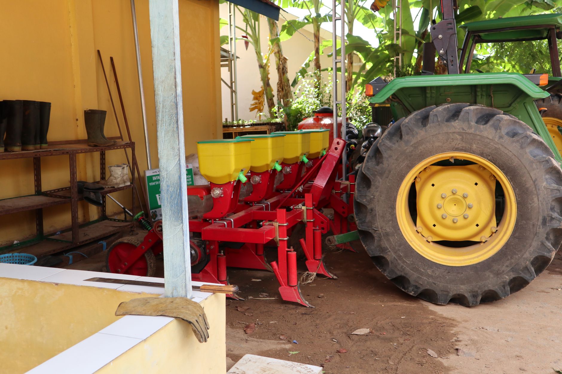 A tractor with a planter machine in a rural farm setting, showcasing essential farming equipment.
