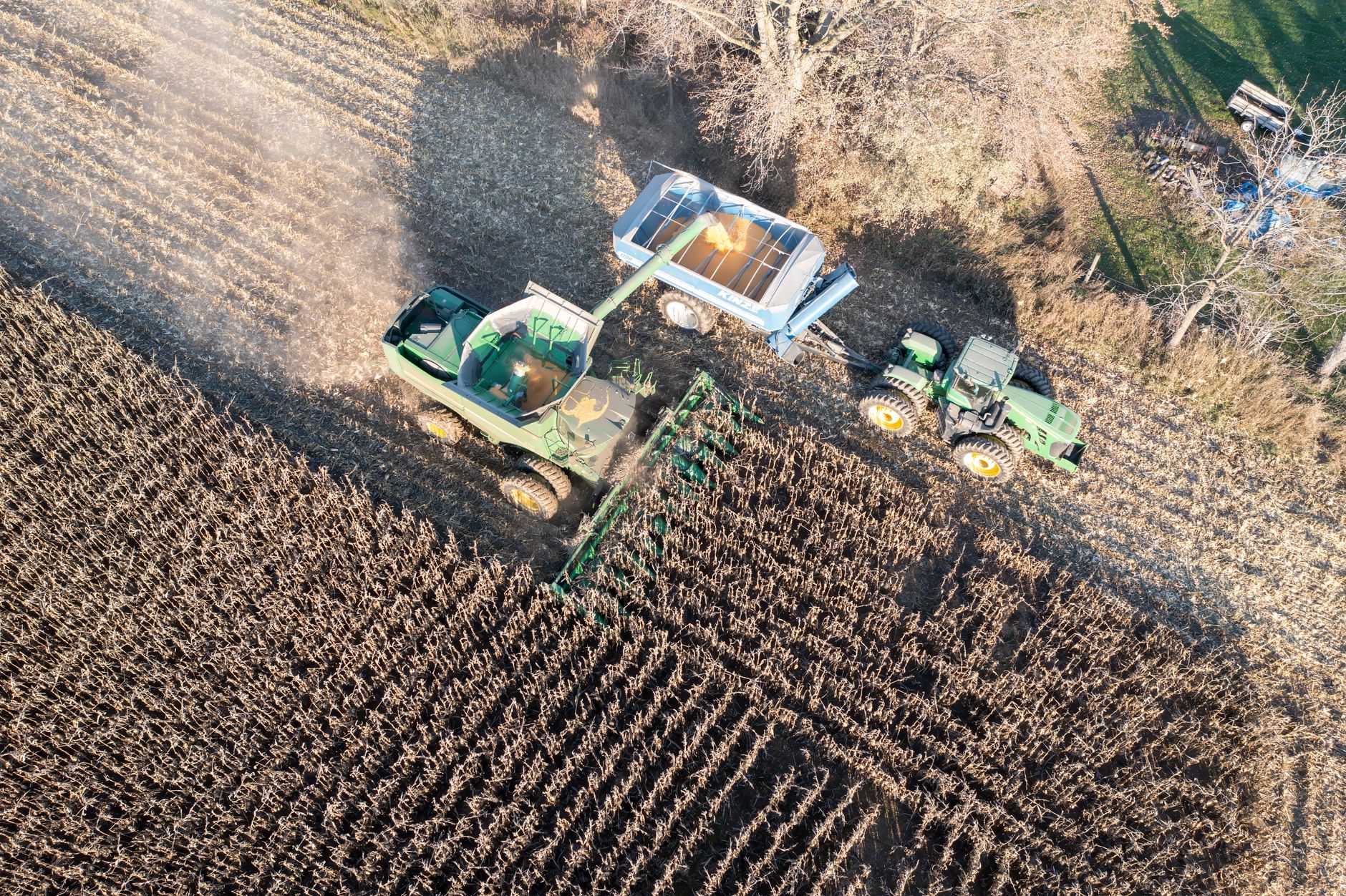 Drone shot capturing a corn harvester transferring to a trailer in Theilman, Minnesota.