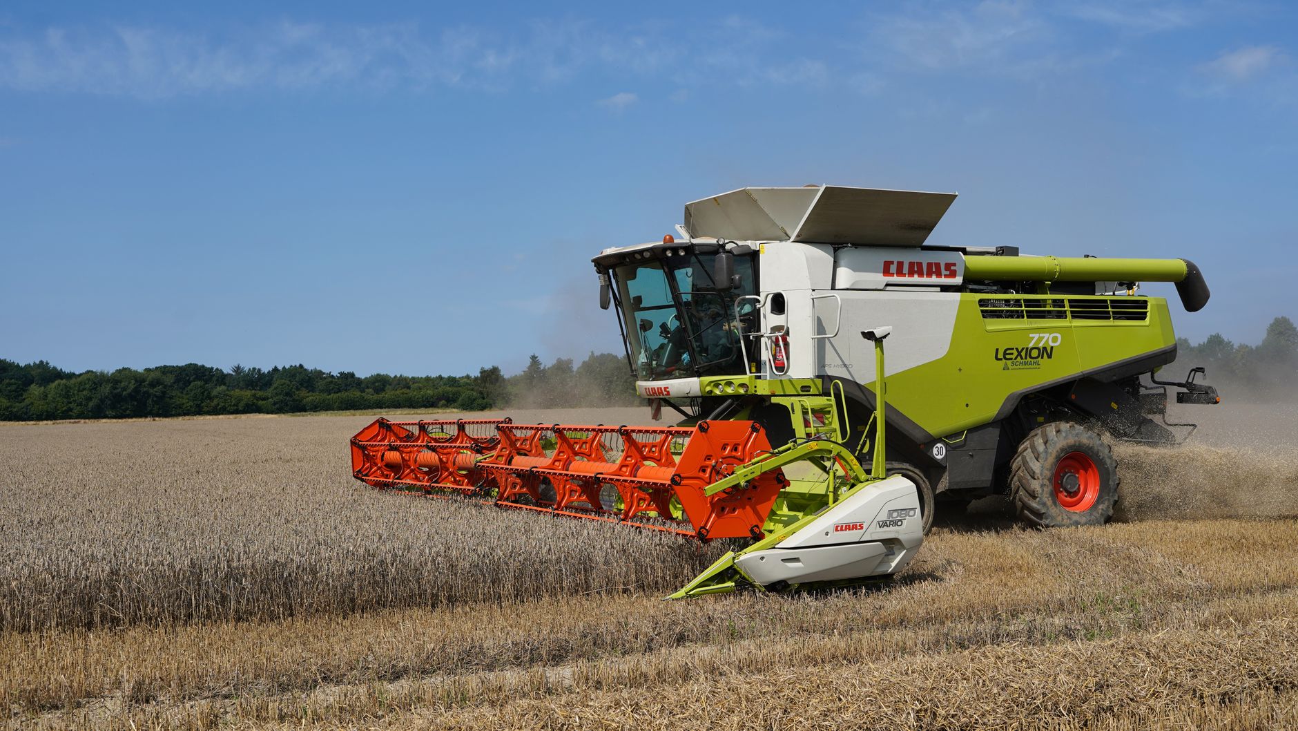 Combine harvester working in a wheat field on a clear summer day.