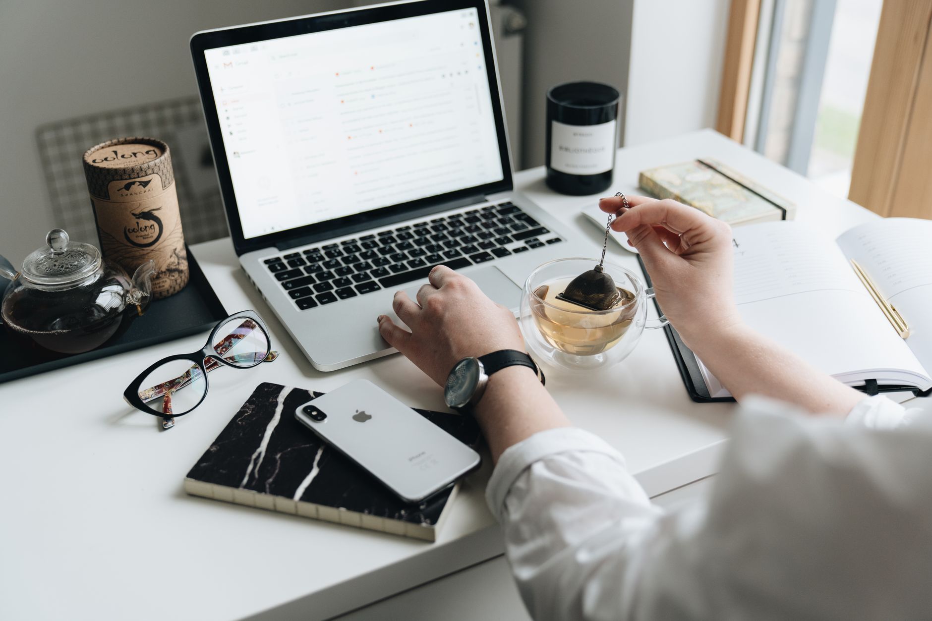A cozy home office scene with a laptop, tea, and workspace essentials.