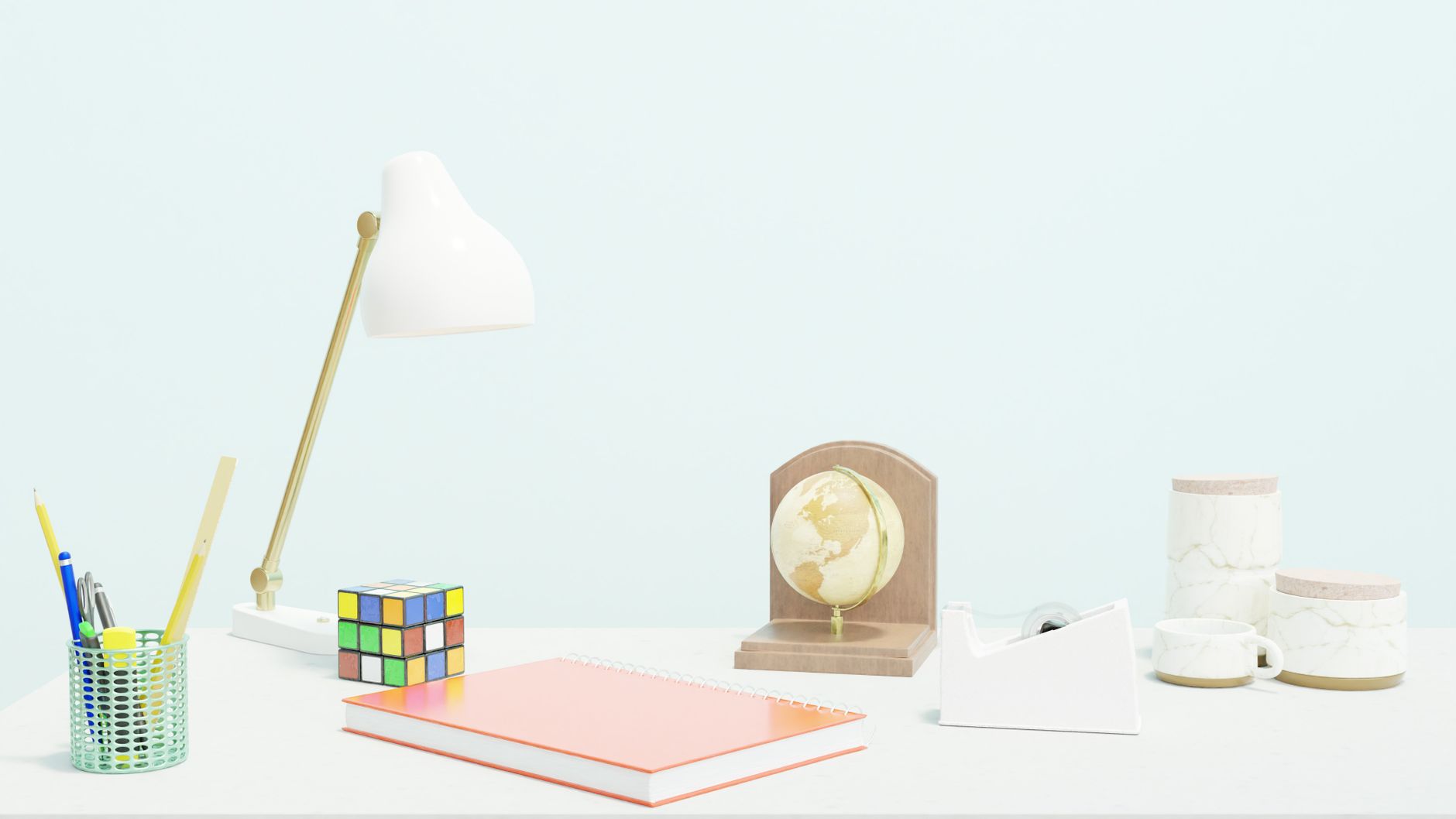 A clean and modern workspace featuring a lamp, notebook, globe, and colorful cube.