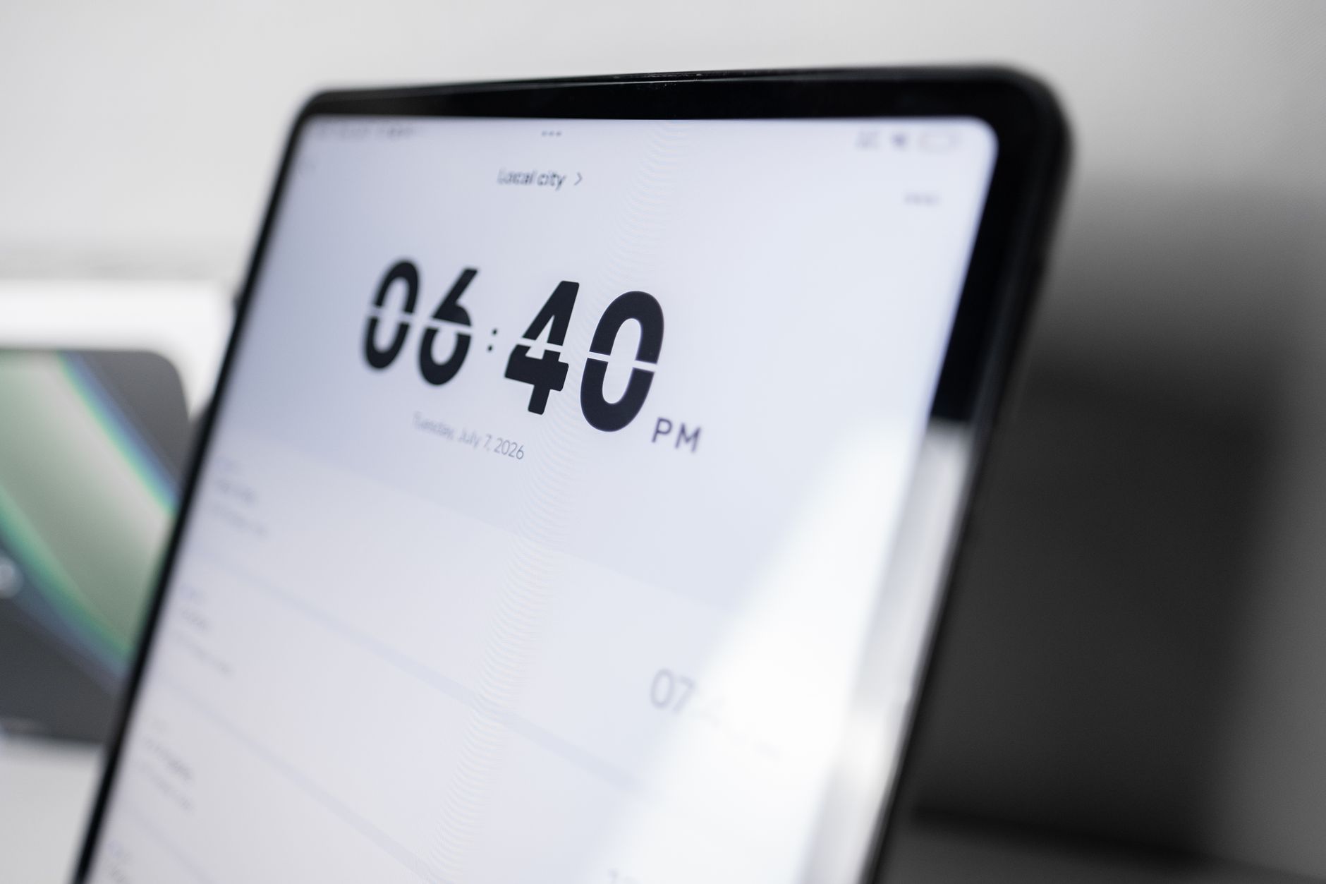 Close-up view of a digital clock display on a tablet showing 6:40 PM in a sleek modern design.