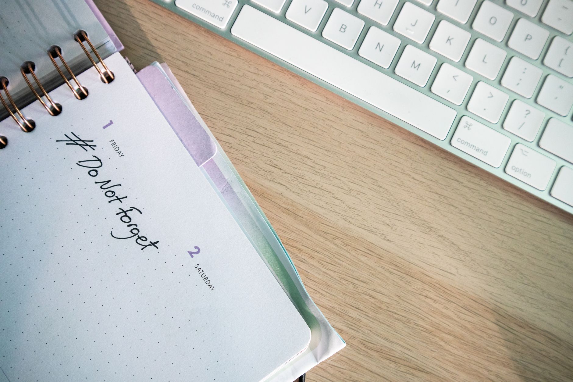 A close-up shot of a planner and keyboard on a desk, showcasing organization.