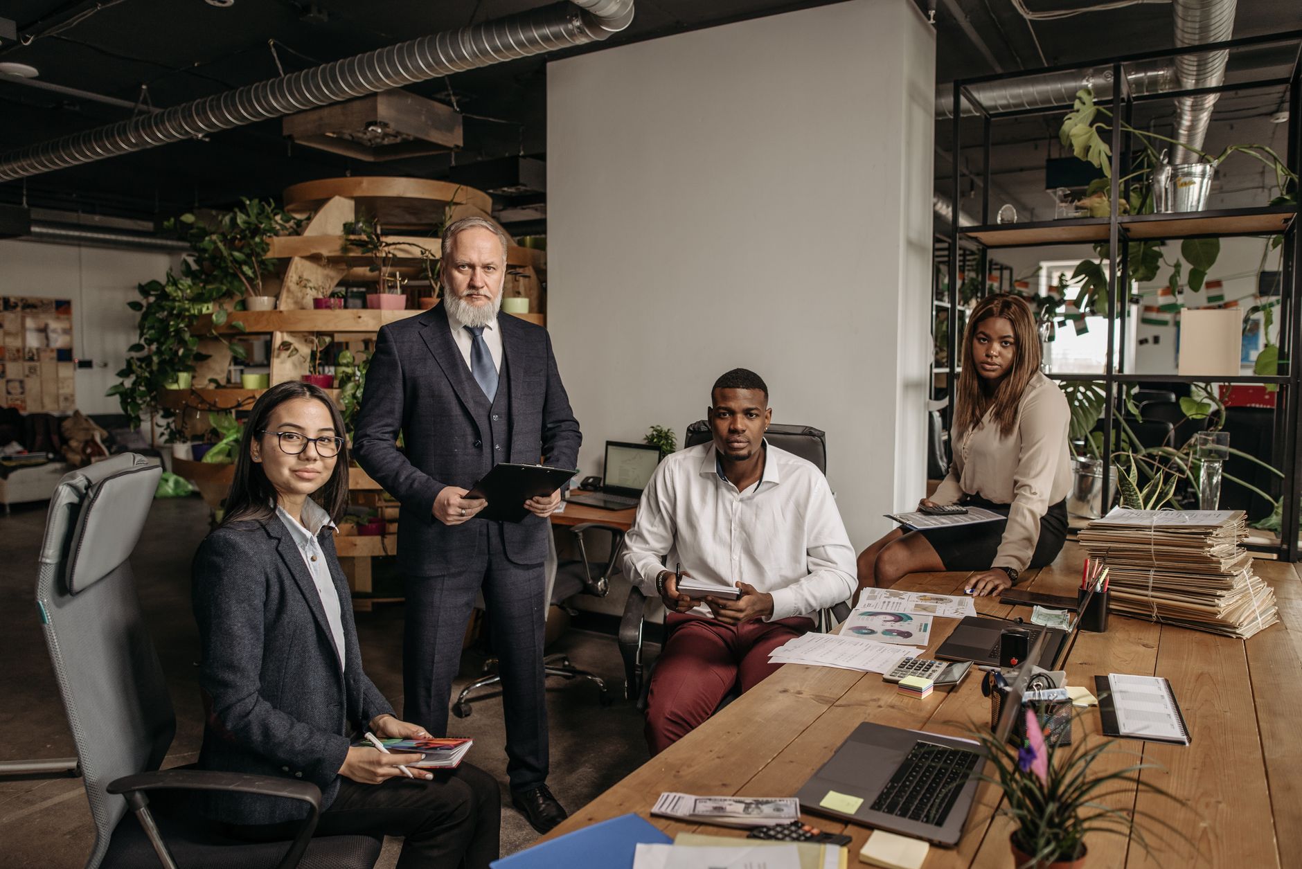 Diverse team collaborating in a modern Portland office with laptops and task management tools
