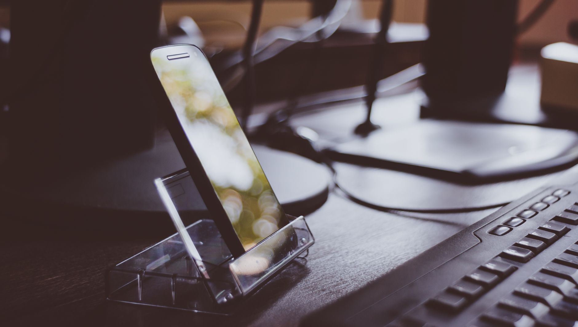 Workspace with smartphone on stand and keyboard, highlighting modern technology and productivity.