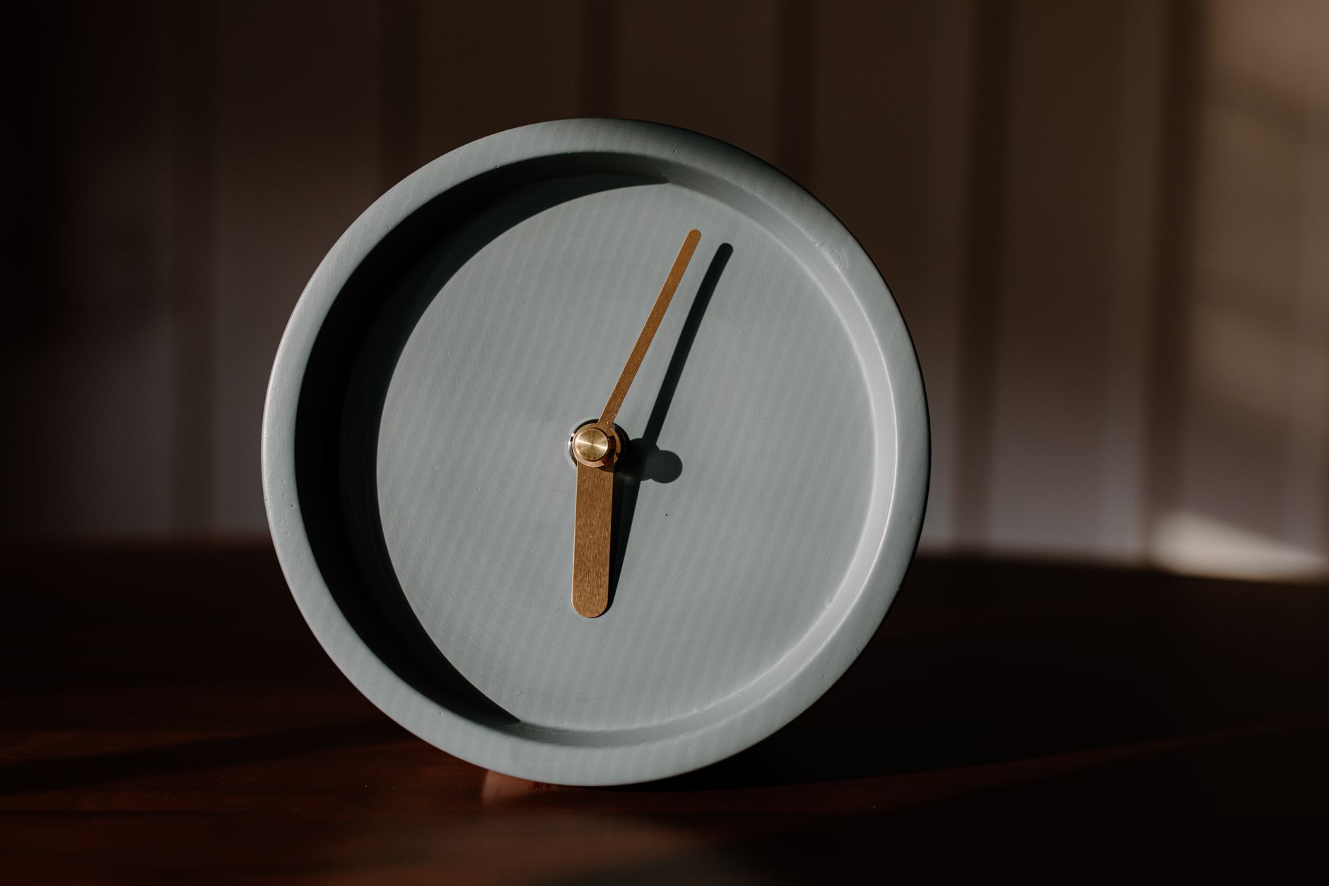 Elegant minimalist alarm clock casting shadows in soft, warm lighting. Perfect for design and time themes.