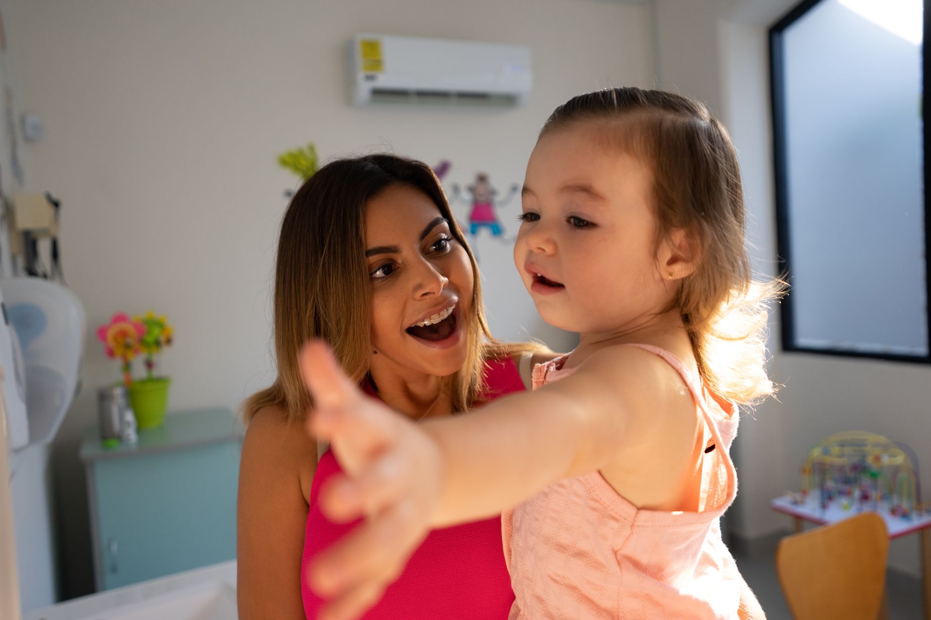 Mother and daughter sharing a joyful moment in a bright, cheerful home setting.