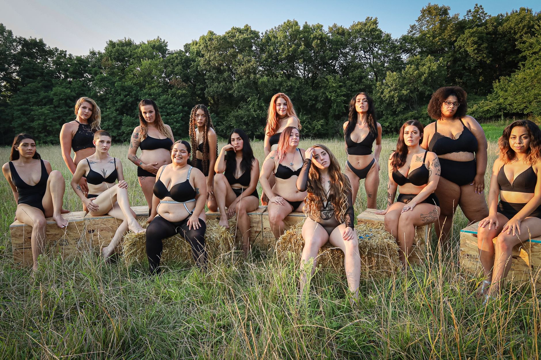 A group of diverse women pose confidently in black lingerie, embracing women empowerment in an outdoor setting.