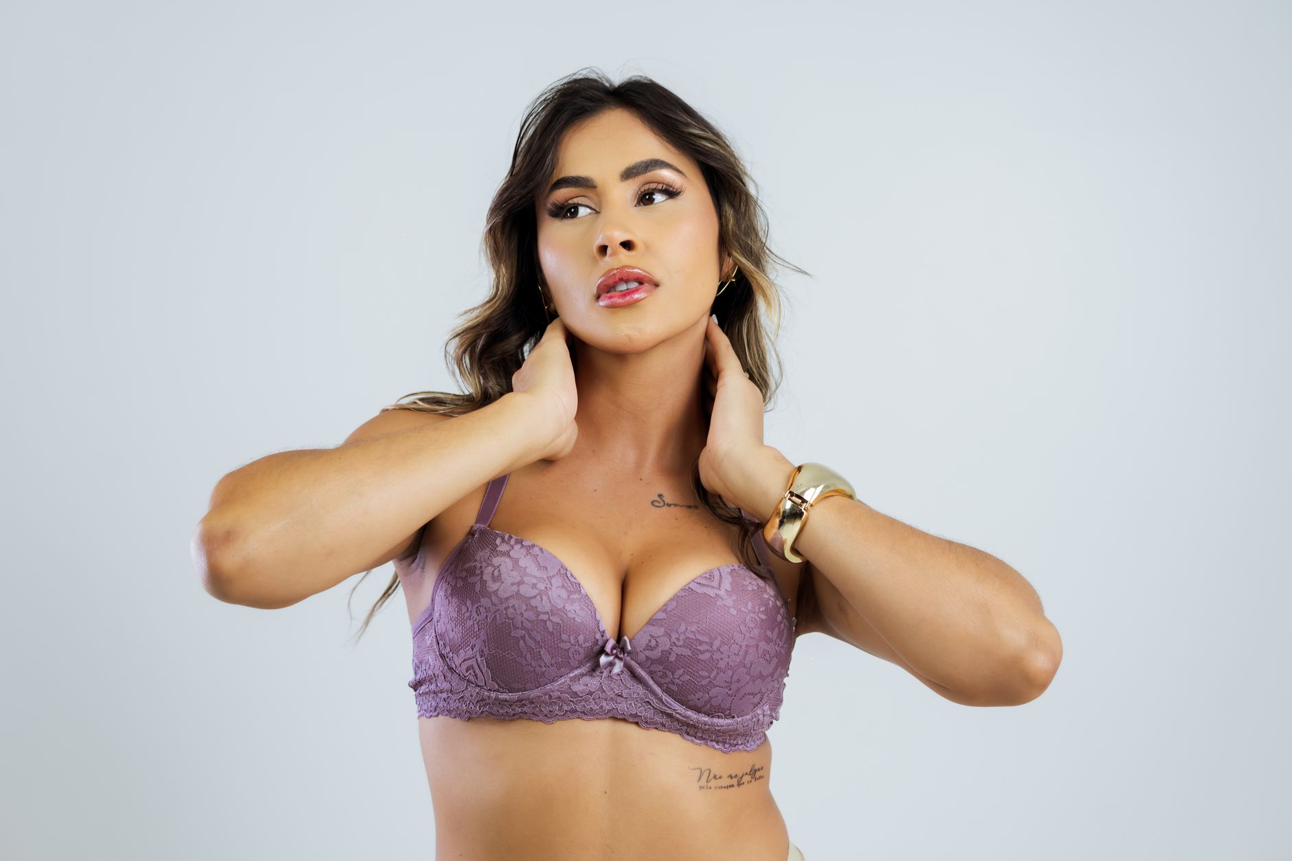 Stylish woman wearing lavender lace lingerie posing with confidence.