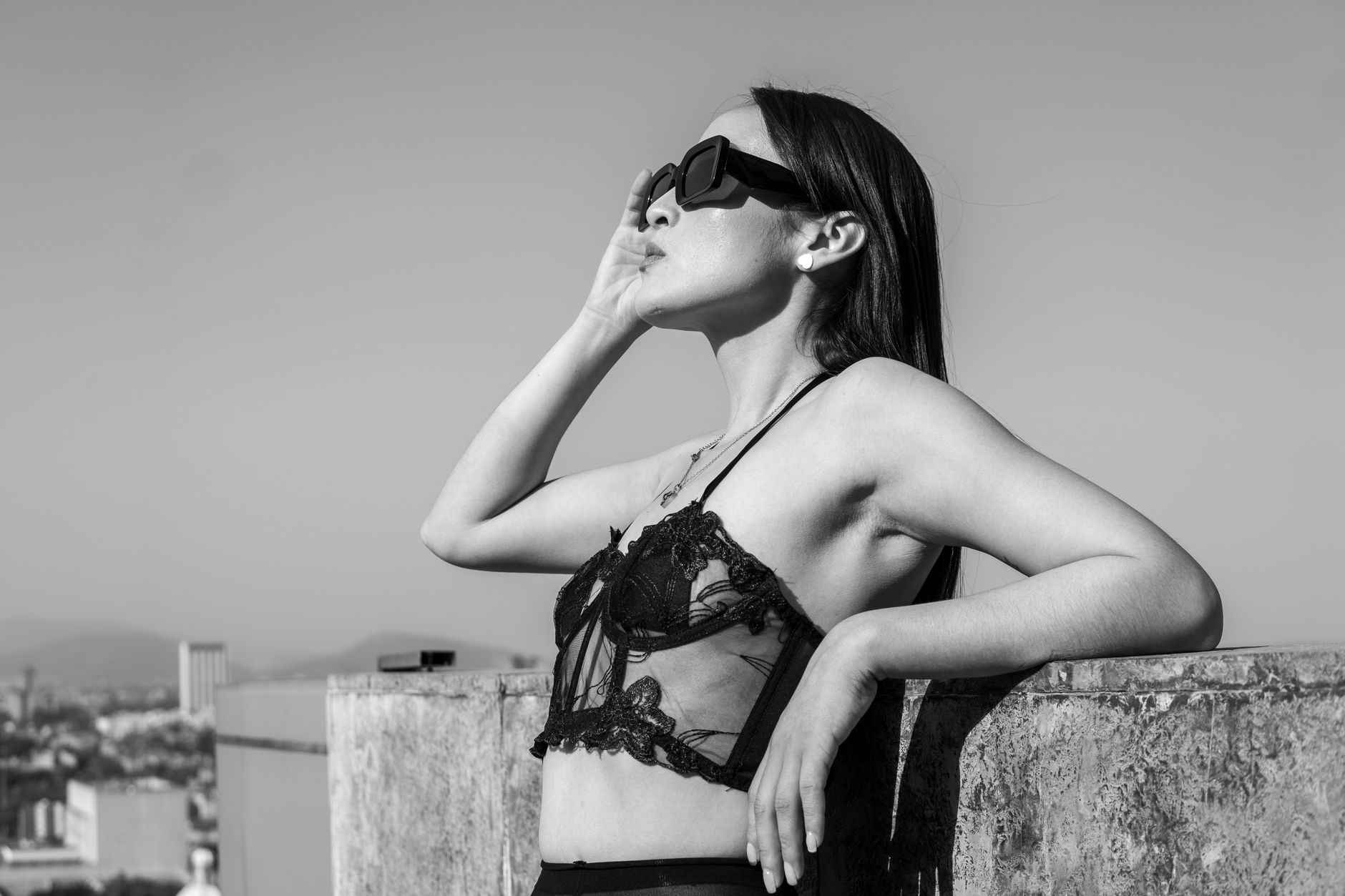 Stylish black and white photo of a model on a rooftop in Mexico City, embracing sunlight.