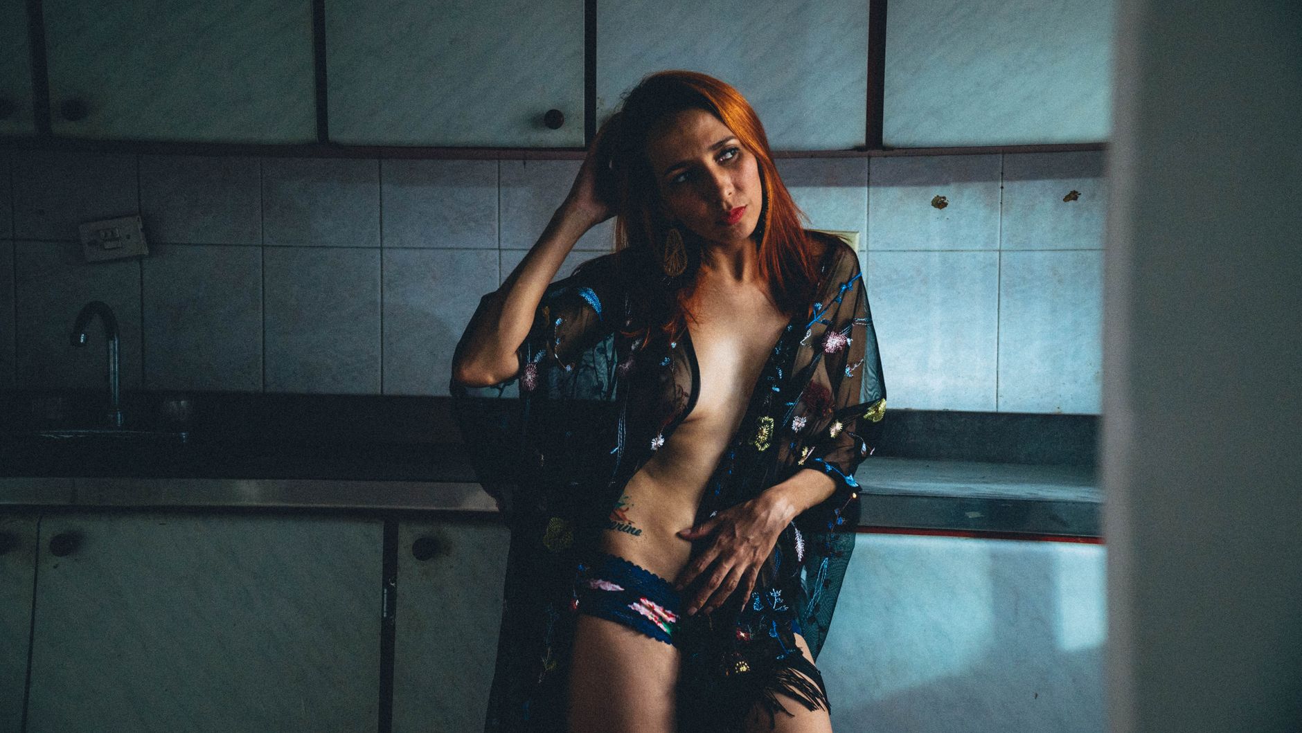 Sensual indoor portrait of a woman in lingerie with artistic lighting and composition.