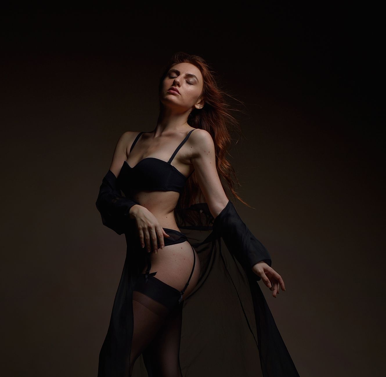 Sophisticated studio shoot capturing woman in elegant black lingerie.