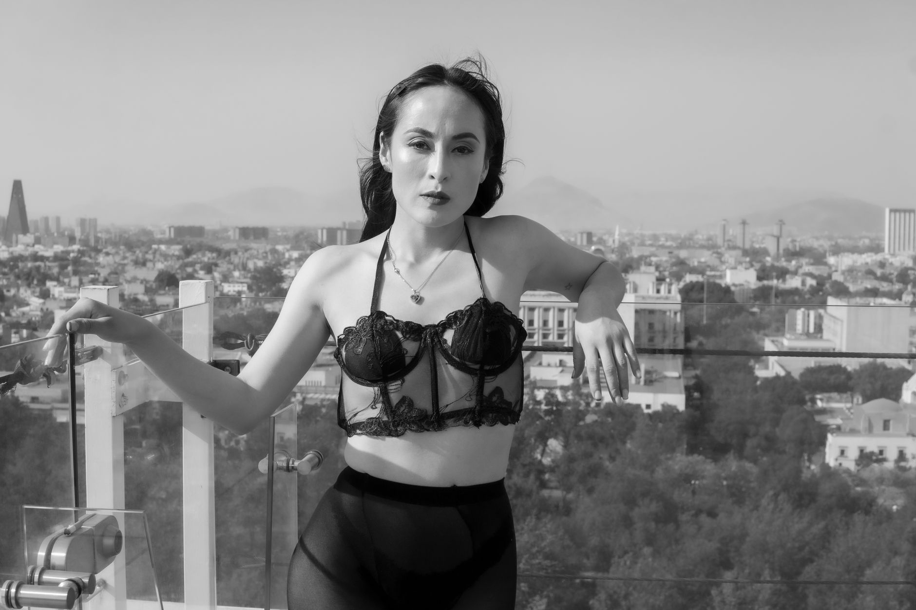 Black and white photo of a woman in lingerie on a rooftop in Mexico City, showcasing urban fashion.
