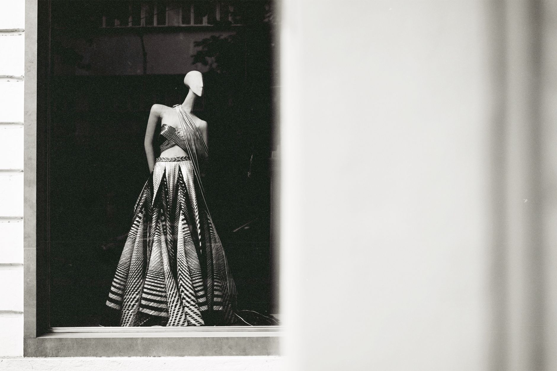 A stylish mannequin showcasing a modern dress in a window display.