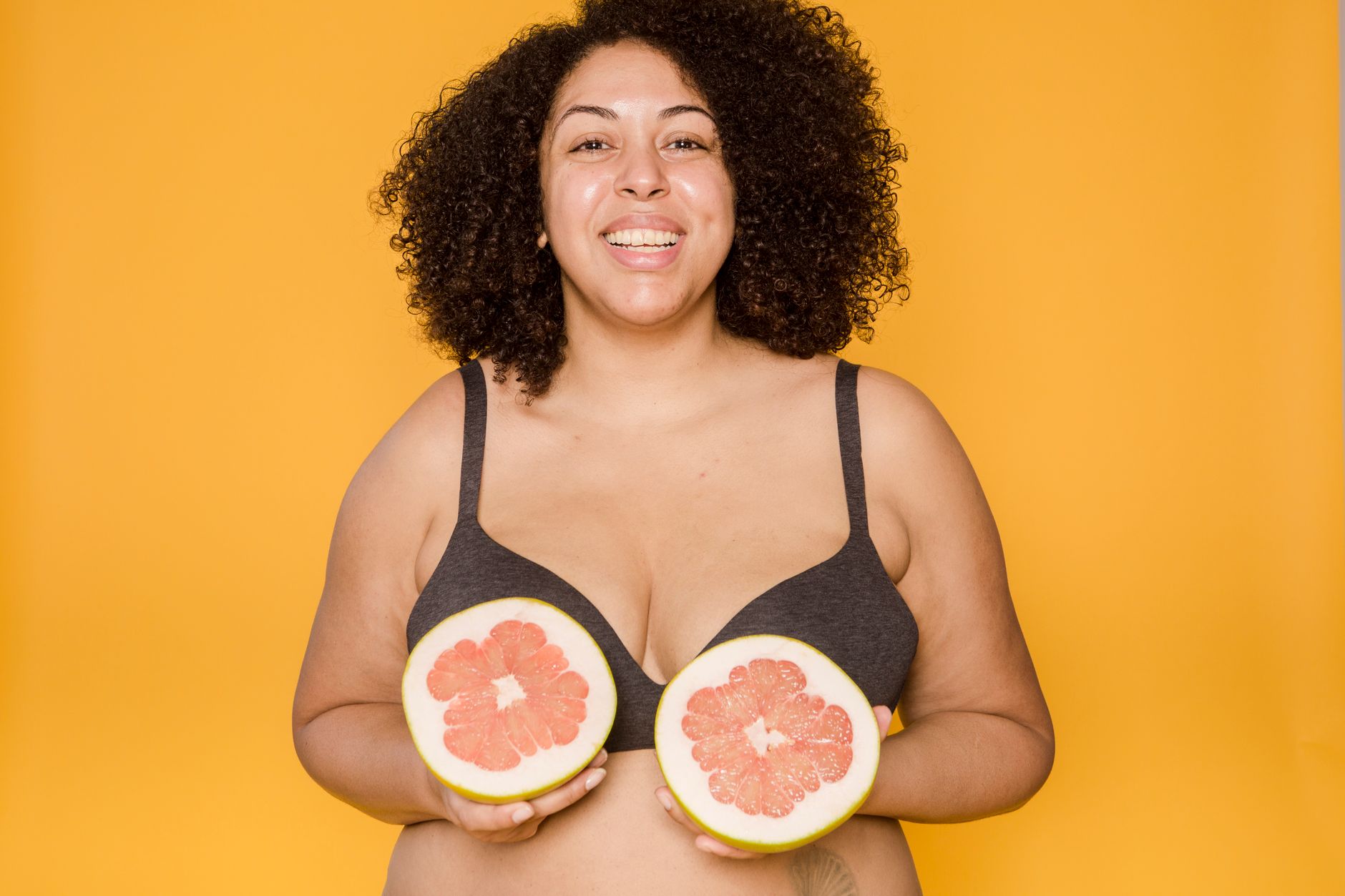 Mulher plus size usando vestido tomara que caia com sutiã invisível, sorrindo