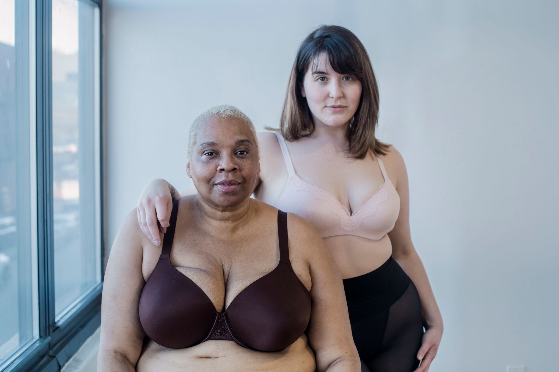 Mulher ajustando sutiã plus size no espelho