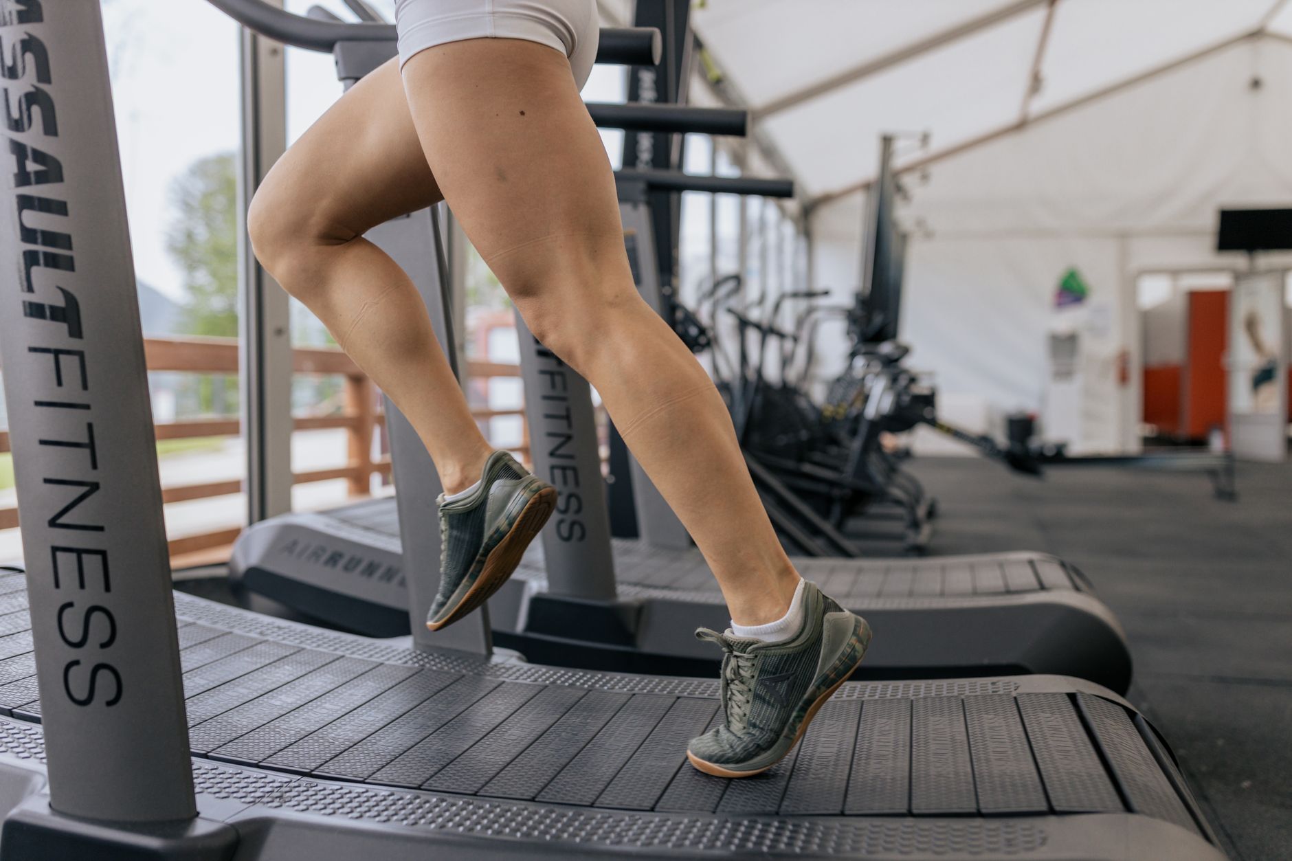 Close-up of a woman's legs running on a treadmill indoors, focusing on fitness and exercise.