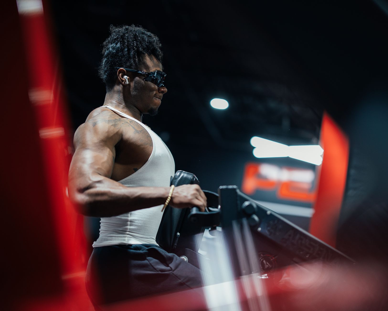 Muscular bodybuilder exercising indoors with intense focus and strength.