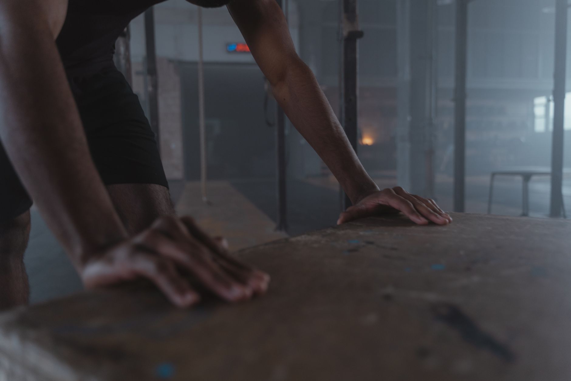 A determined athlete practicing push-ups indoors with focus and strength.