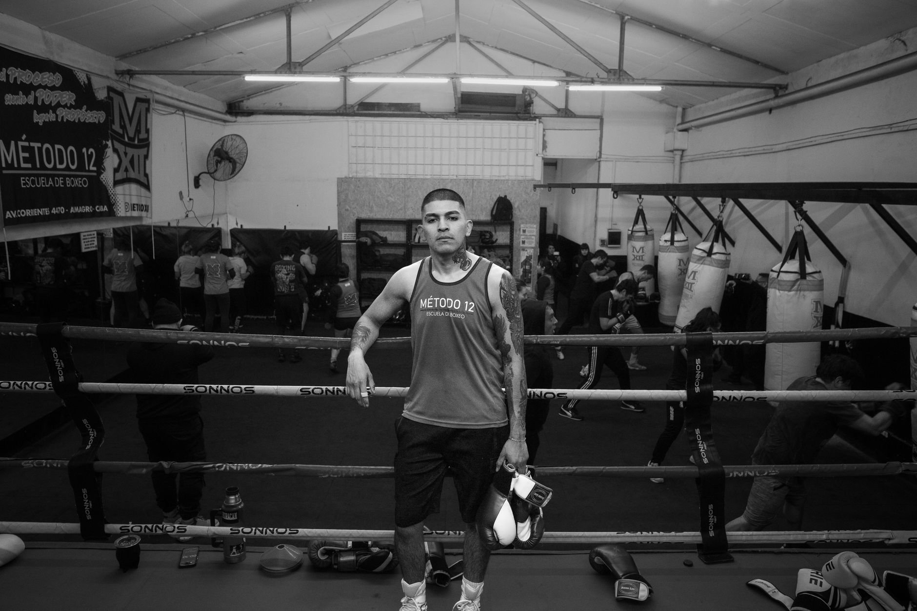 A boxer stands confidently in an indoor boxing gym in Argentina, ready to train.