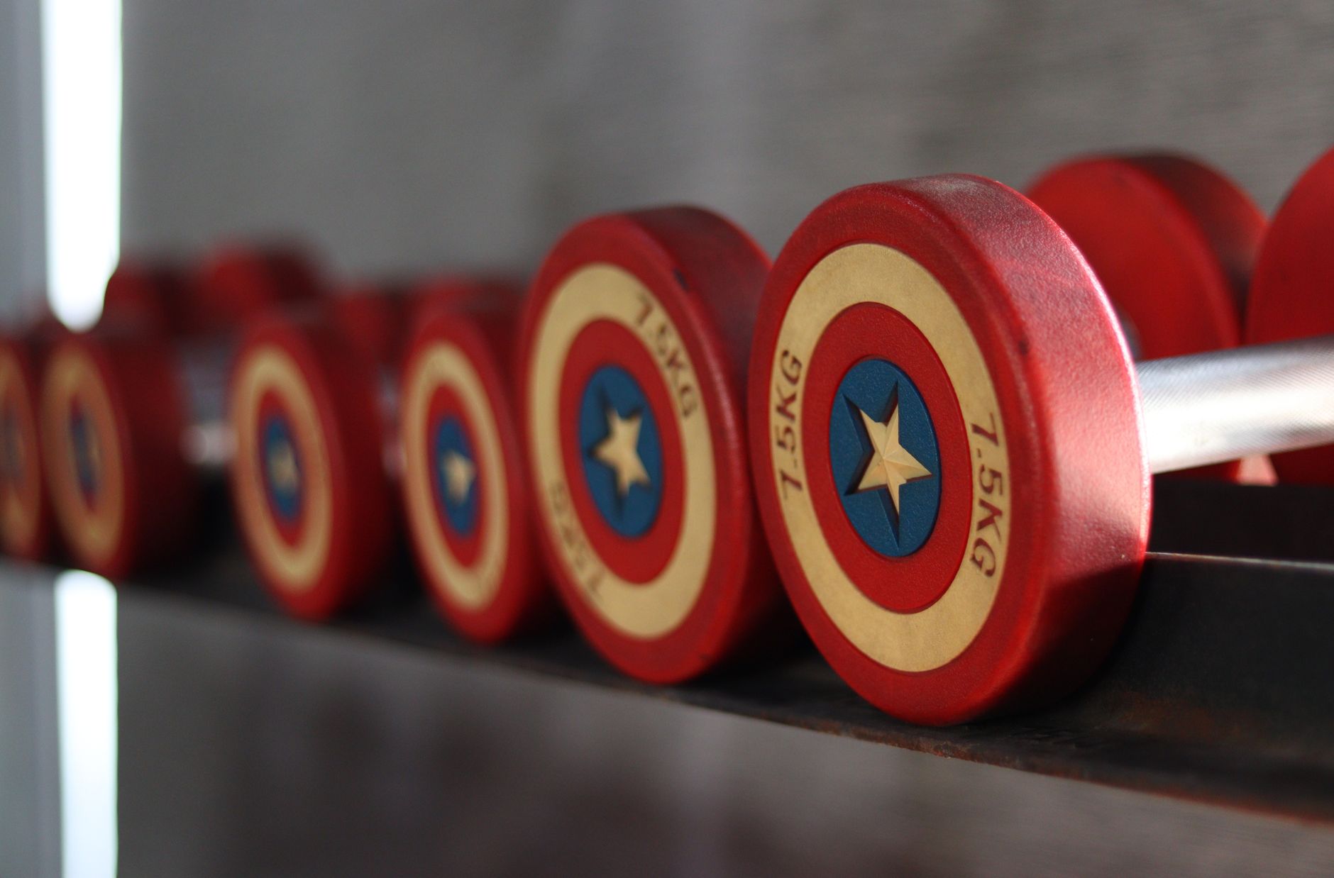 Close-up of red dumbbells with star design in a gym setting, ideal for fitness themes.