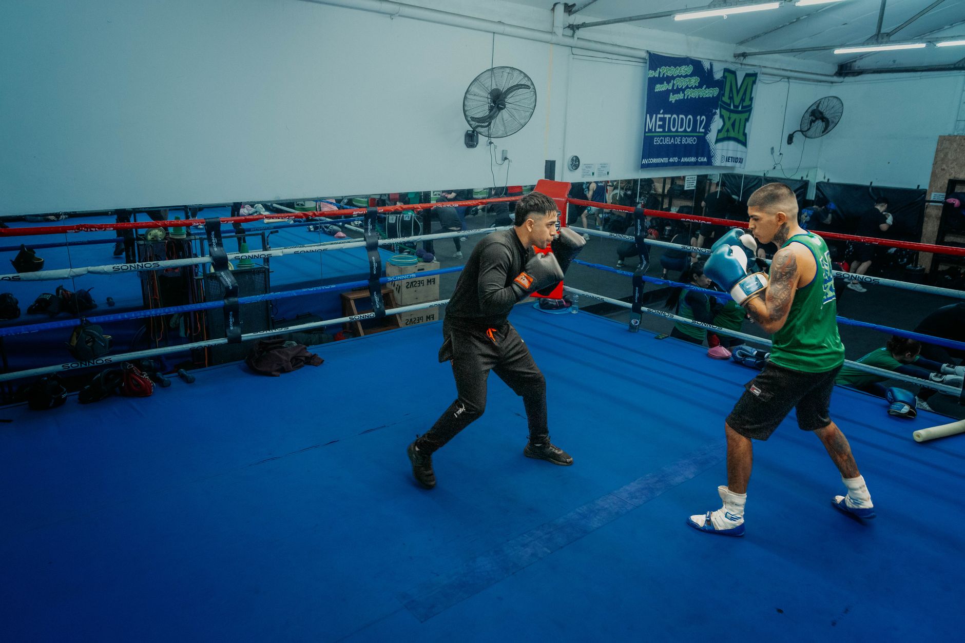 Two boxers sparring in a gym in Buenos Aires, showcasing intense training.