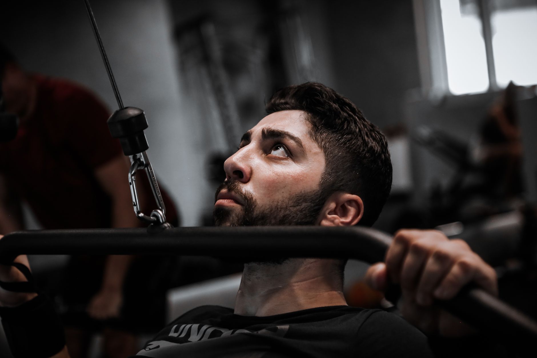 Muscular man working out with determination on gym equipment.